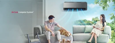 Mladi par sjedi na kauču u dnevnom boravku sa svojim psom dok klima uređaj LG AirCare Complete System hladi prostor.